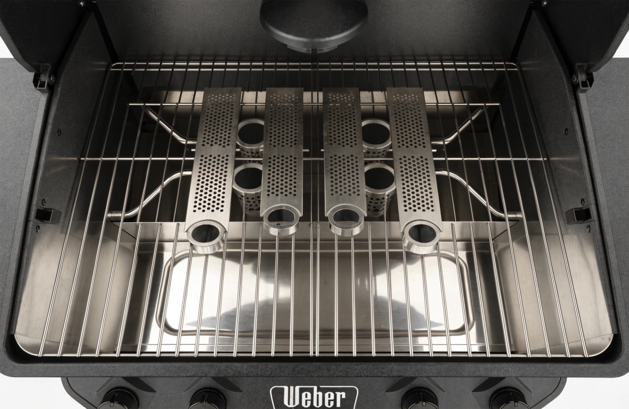 Inside a professionally cleaned Weber BBQ showing clean burners and drip tray